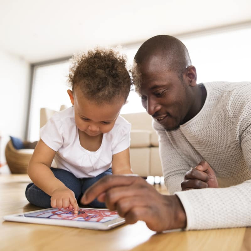 Father using a tablet with his young daughter