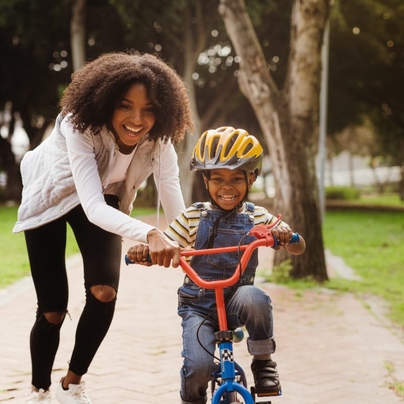 Mom teaching her son to ride a bike