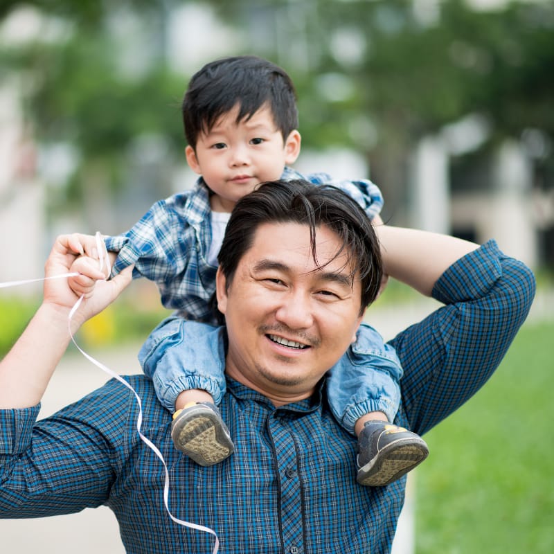 Father carrying his young child on his shoulders