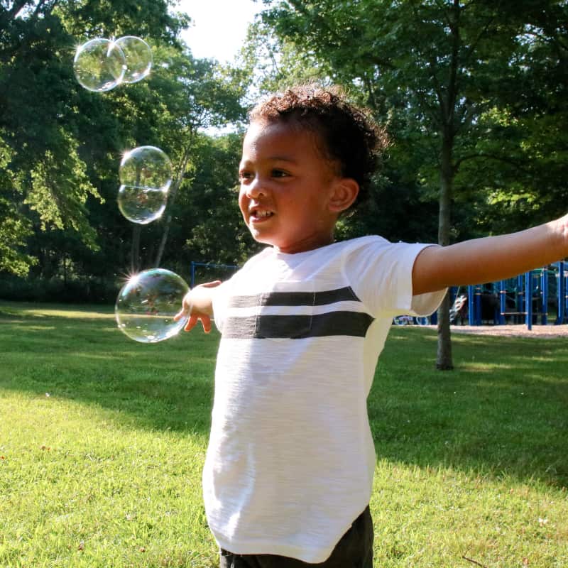 Boy blowing bubbles in the park