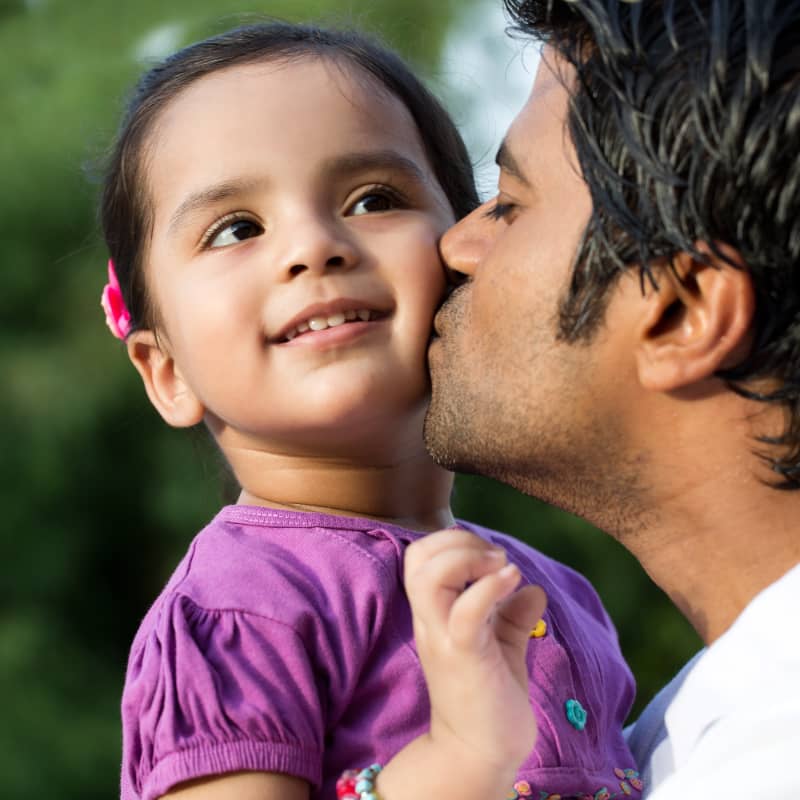 Father kissing his young daughter